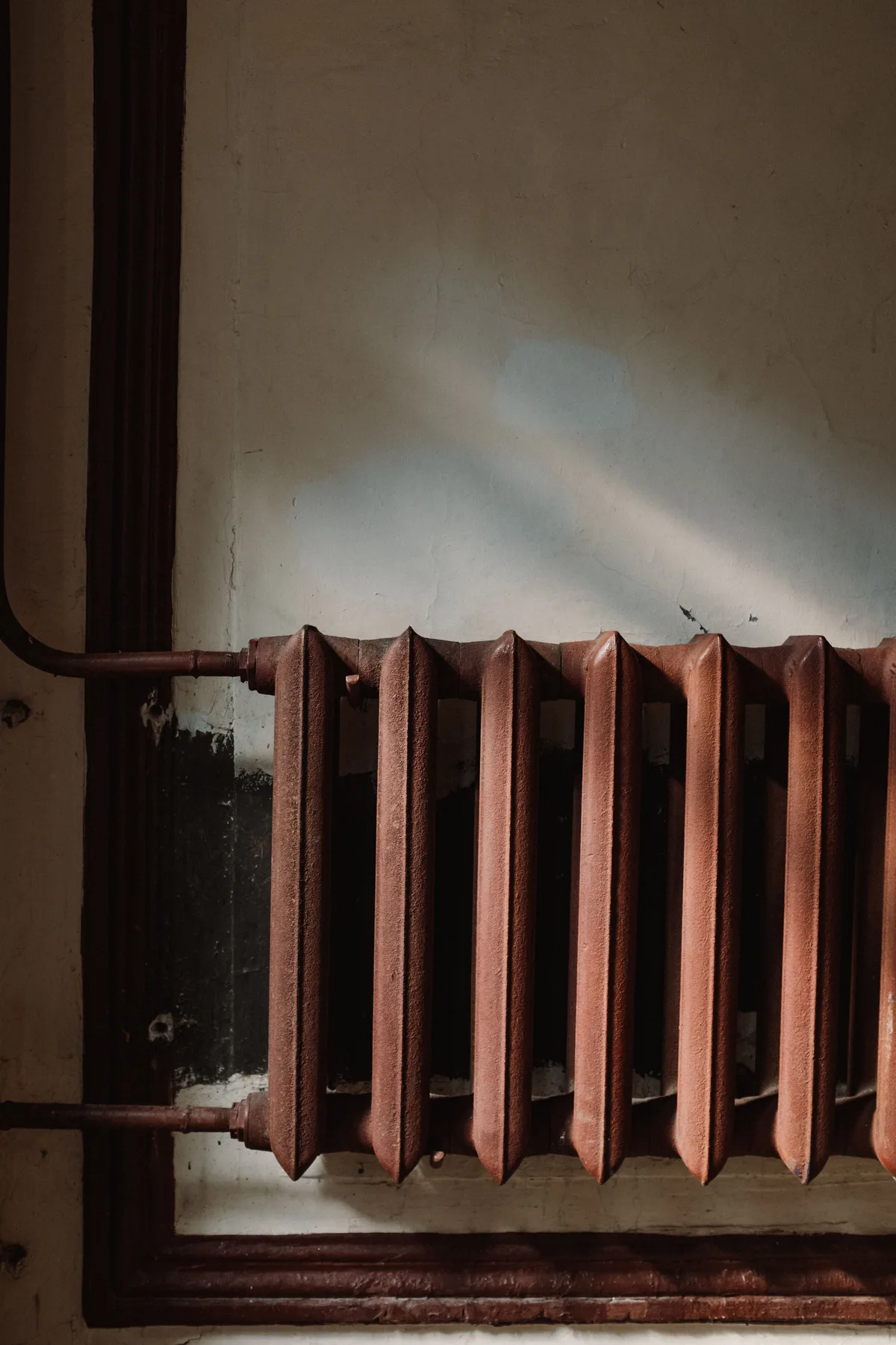 Oude radiator tegen een muur in een woning