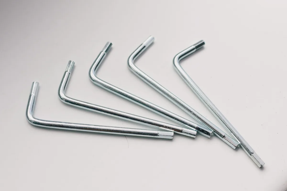 Five silver hex keys fanned out on a white surface