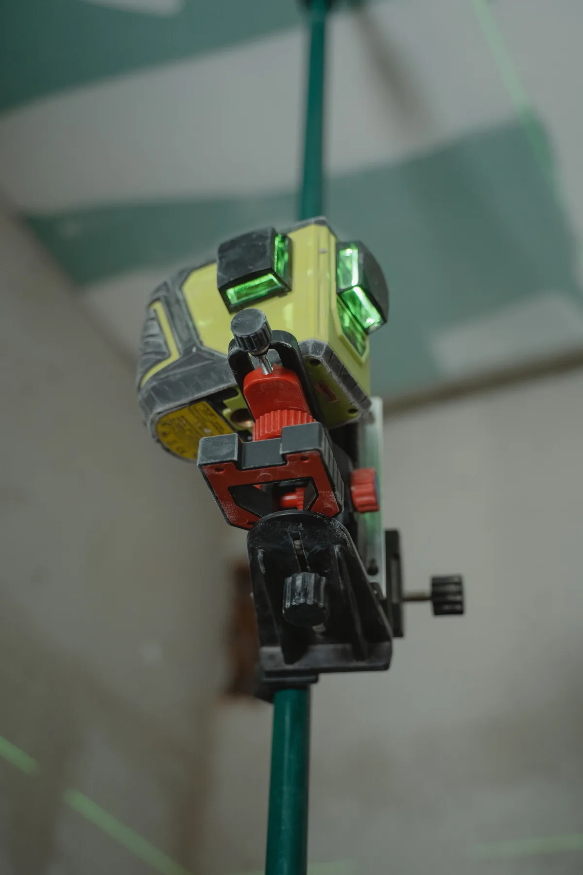 Close-up van een lijnlaser met groene vensters op een statief