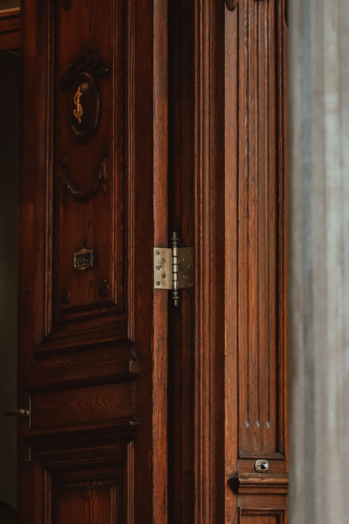 A wooden door with a hinge in a classic frame