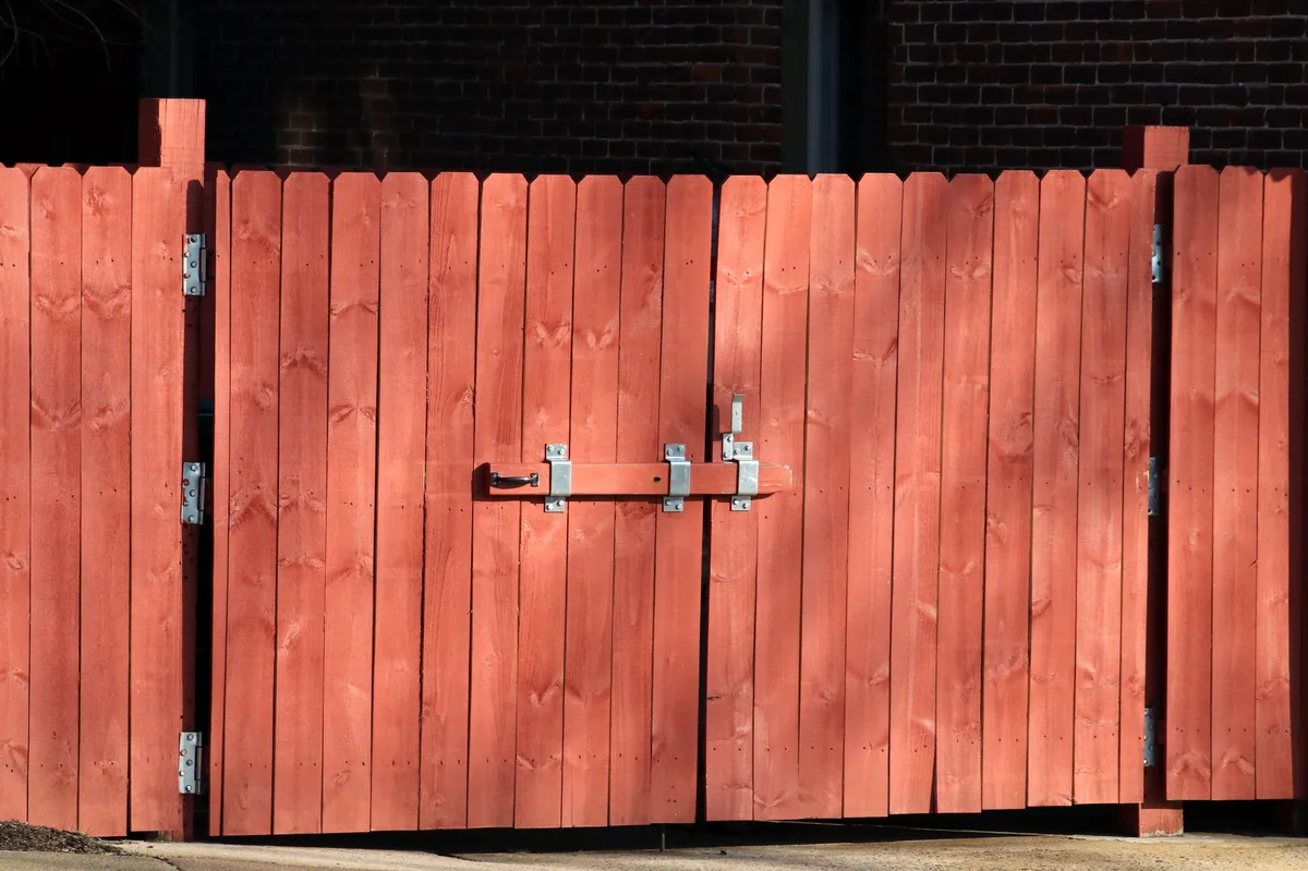 Dichte houten schutting met poort, staanders en verzinkt beslag