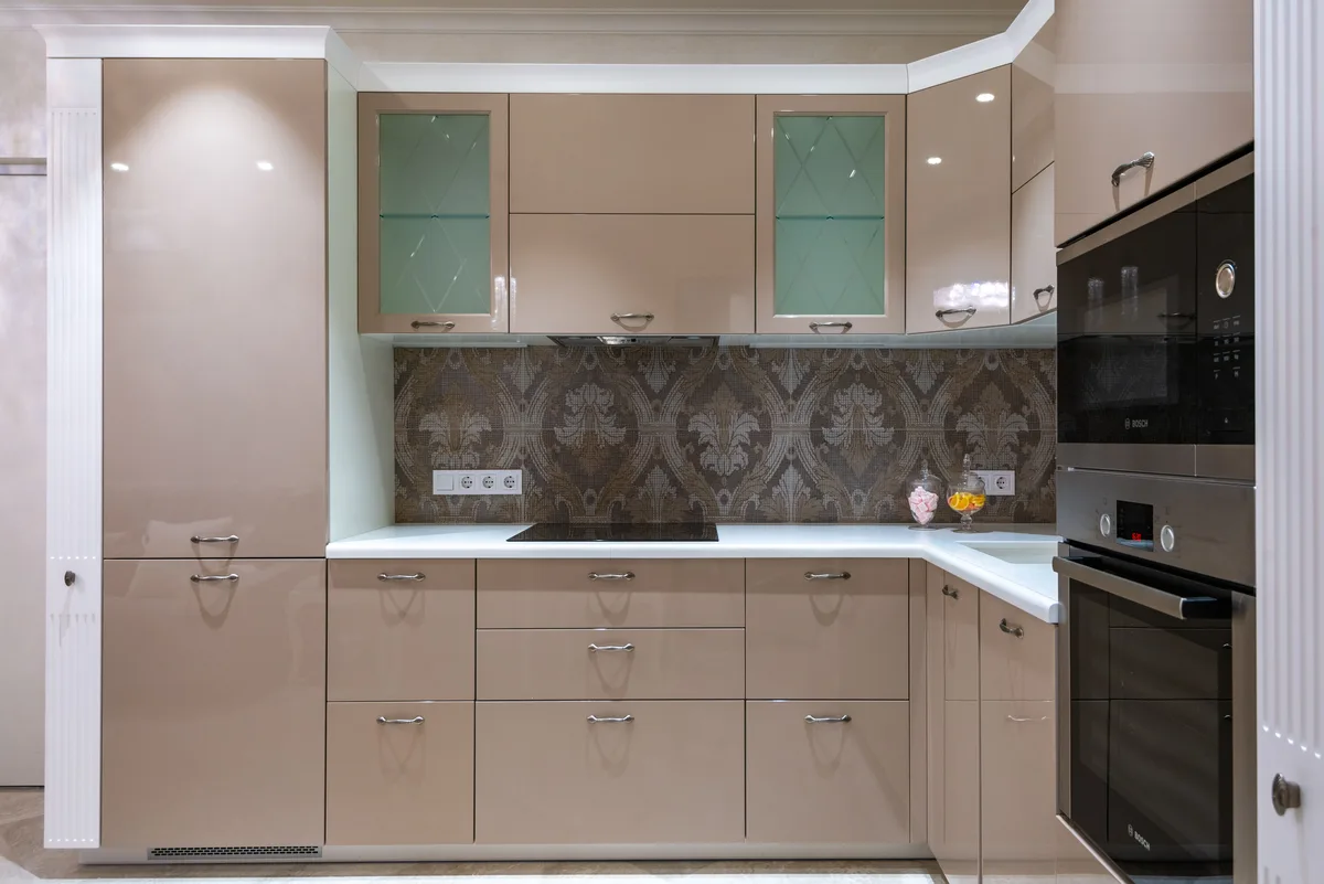 A modern kitchen with built-in appliances and a patterned splashback